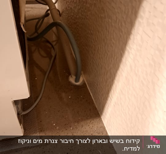 צינור מים מחובר לקיר ליד מכשיר חשמלי
